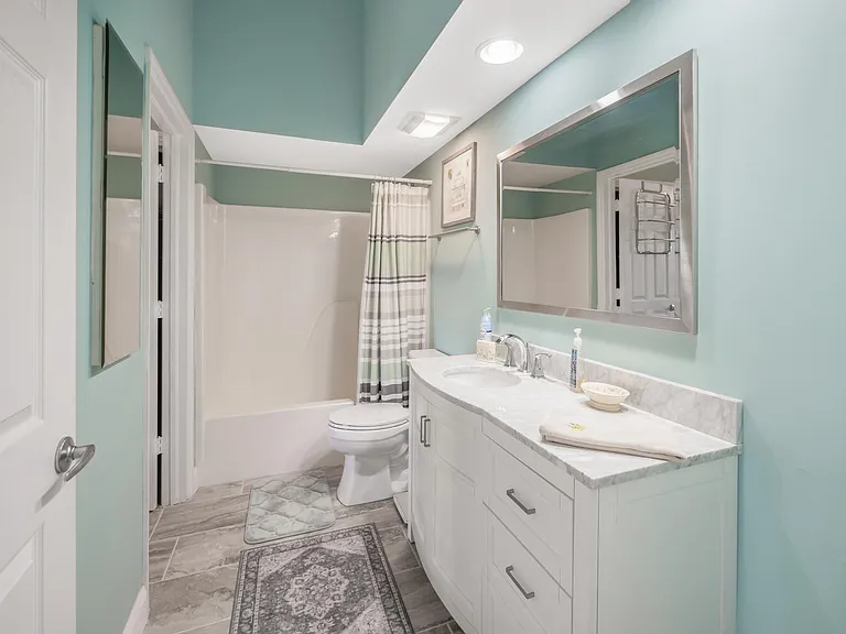 Hall bathroom with tub combo shower, accessible also directly from guest room.