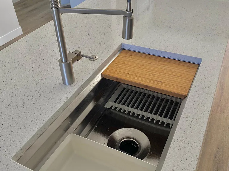 Large kitchen sink with multiple accessories and racks that are removable.