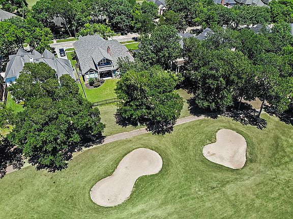 Aerial view of the back of the home and its location along the sand traps on the 9th hole