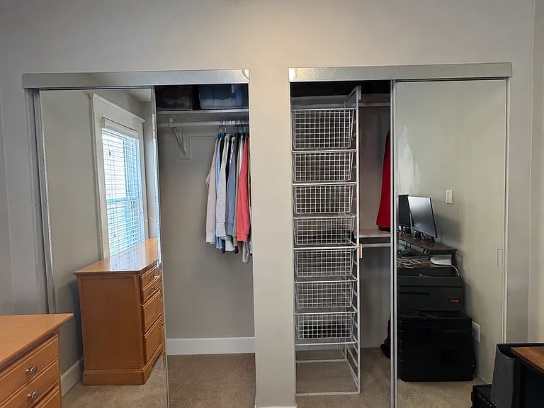 Primary bedroom large closet space with built in storage shelving system
