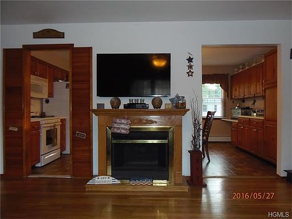 View of gas fireplace in living room with open floor plan to kitchen