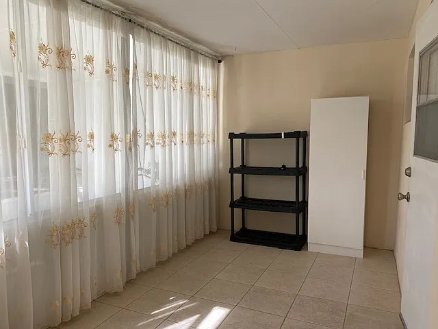 Enclosed space, between porch and bedroom.