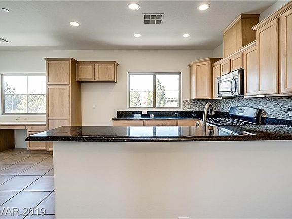 Great working kitchen space with pantry unit, full tile backsplash and granite countertops.