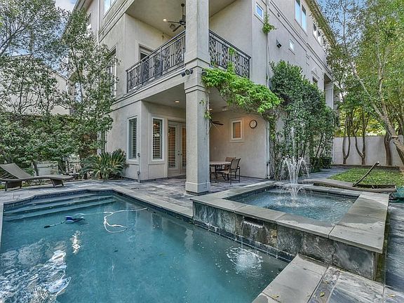 Fully fenced backyard oasis highlighted with a lovely pool, fountain and large slate patio. The lush landscaping adds to it's park-like feel.  The backyard patio can be accessed from the front of the house and through the french doors in the office and first floor bedroom/flex space.