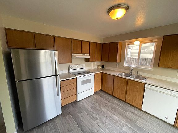 Kitchen has huge fridge and smooth top electric range.
