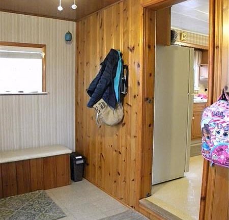 ENTRY: 13x6 Entry with vinyl tile and pine-sided wall leading to the kitchen.