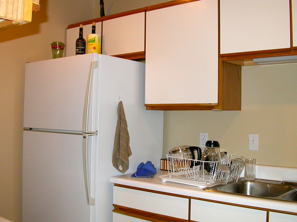 Kitchen with refrigerator and stainless steel sinks.
