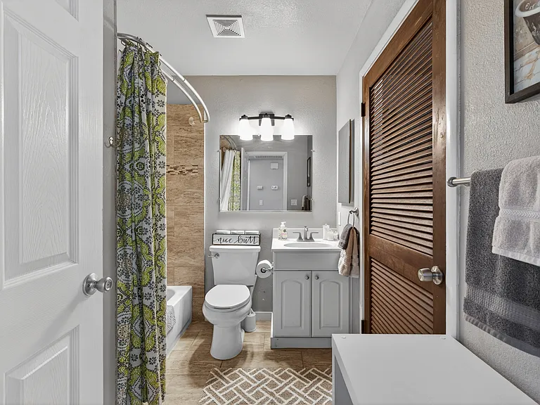 Bath with tile floor and shower. Laundry Room behind the wooden door
