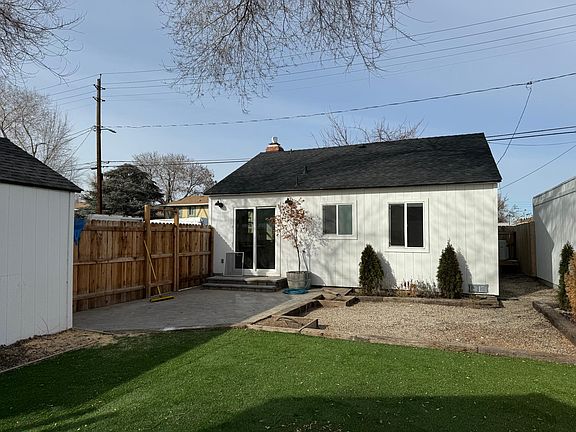 view from backyard. artificial turf, cedar fence, and landscaped.