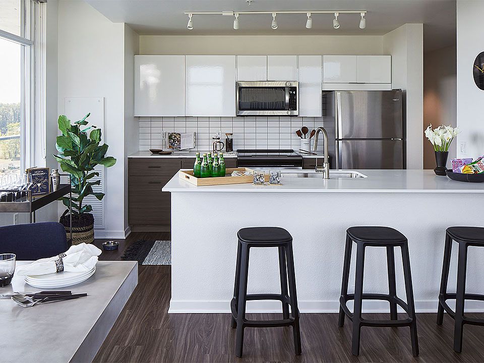 Apartment Kitchen with Stainless Steel Appliances, quartz counters and wood floors.