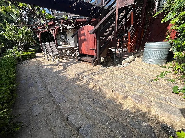 Paved patio stairs off of the exterior stairs, entry into back yard from tub