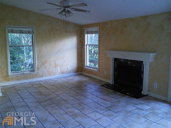 Great room with tile floor and window views of thick forest for privacy and quiet.