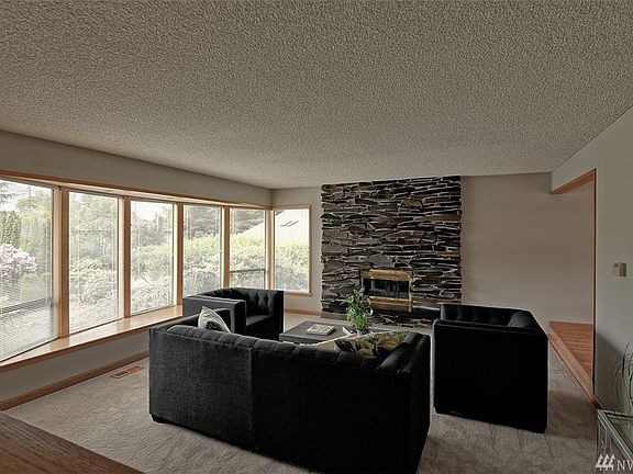 Expansive bay window captures the beautiful grounds and peek-a-boo sound view.