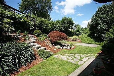 Mature landscaping with a trickling brook and pond