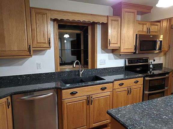 Kitchen with stainless dishwasher, double oven, built-in microwave, refrigerator with icemaker, disposal, window above the sink