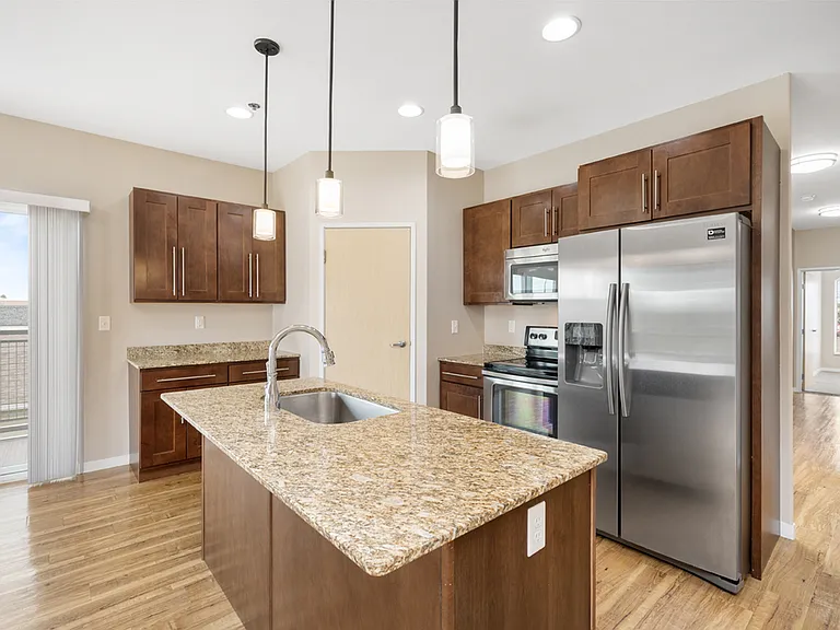 Modern kitchen with granite countertops, stainless steel appliances, and elegant pendant lighting. Modern kitchen with granite countertops, stainless steel appliances, and elegant pendant lighting.
