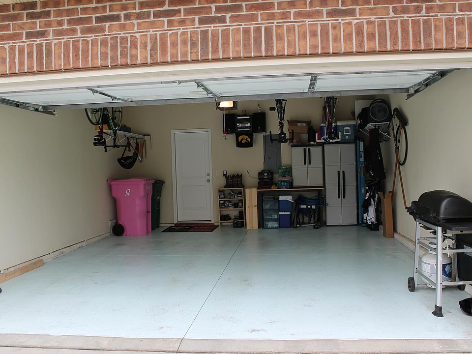 Garage with epoxy floor fits 2 vehicles with ample storage.