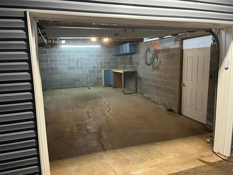 Inside garage new garage door opener with remotes. work bench with storage.