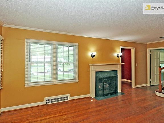 Enter the home thru a foyer before stepping into the spacious living room with fireplace.