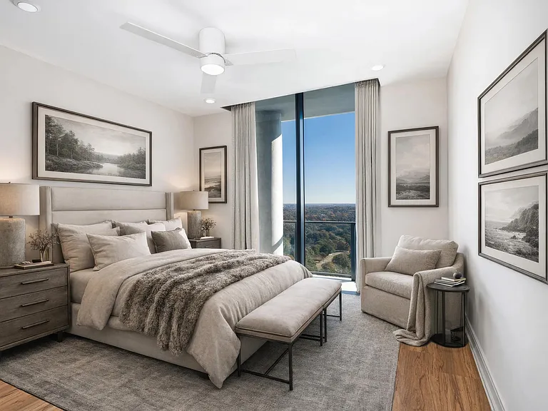 This penthouse bedroom pairs floor-to-ceiling windows with warm textures for a space that feels open and balanced.
