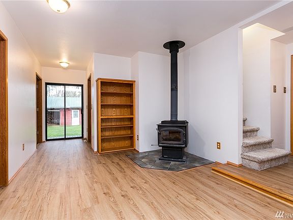 New upgrade vinyl flooring on main floor allows for beauty and easy care.  Den with wood burning free standing fireplace and custom built bookcase.  Ahead to left is door to bedroom and door to right downstairs main 3/4 bath.  New interior paint throughout.