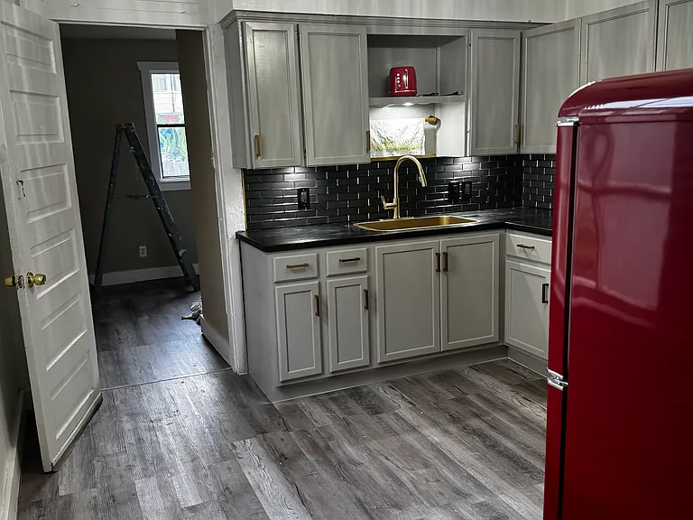 Brand new appliances in spacious kitchen with ebony counters and generous cabinetry.