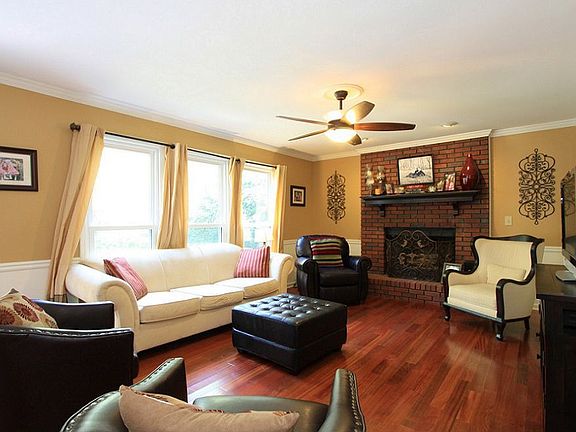 Bright family room with brick fireplace and gas starter & blower.