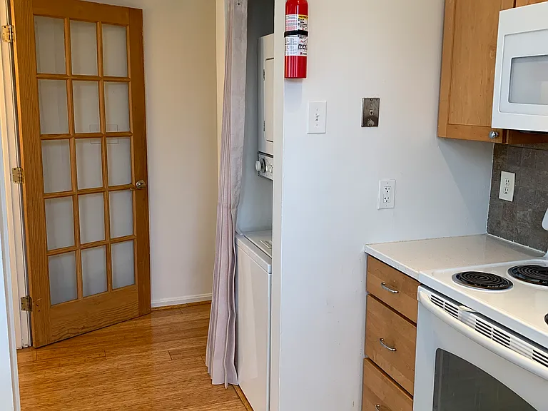 Partial view of kitchen and W/D with accordion closure for the W/D.