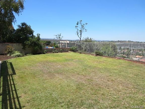 Large yard with panoramic sunset and city light views.