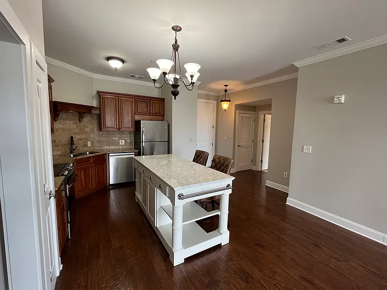 Marble-top island in the open-concept kitchen provides elegant style and function. It adds a bright, classy focal point that visually connects the kitchen to the living space.