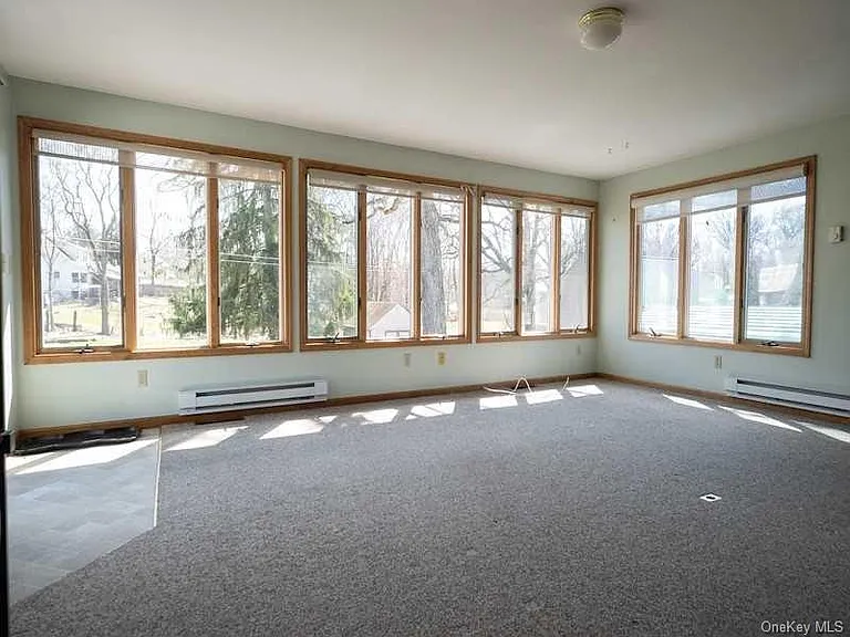 Large Sunroom overlooking backyard with deck, full bath (sep toilet closet, and shower), small closet, and bar sink area.