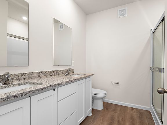 The master bathroom has a dual sink vanity and a step in shower.