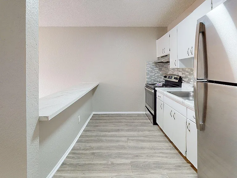 Modern kitchen with sleek stainless steel appliances, stylish cabinetry, and elegant countertops perfect for culinary delights.