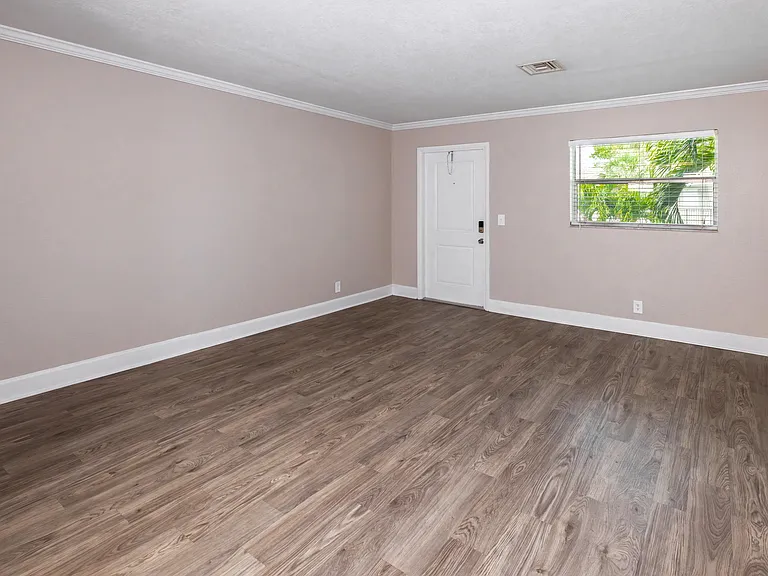 Bask in comfort within a spacious living room with sleek floors and ample natural lighting, creating an inviting and refreshing retreat where you can feel relaxed.