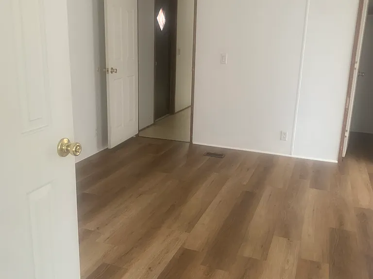 master bedroom looking toward back door that goes onto deck. Cathedral ceiling with large closet in master