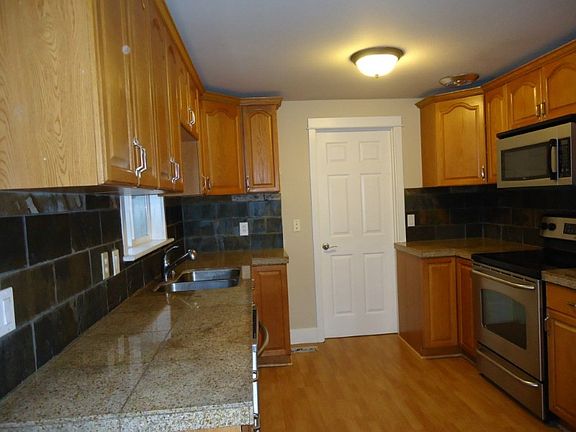 Updated kitchen with granite counter tops and stainless stove, dishwasher and microwave. Utilitiy room is beyond the door.