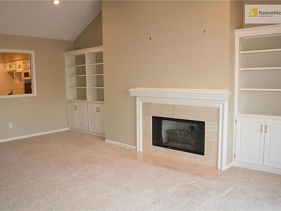 Living/Dining room offers a gas log fireplace surrounded by cabinets and bookcases.