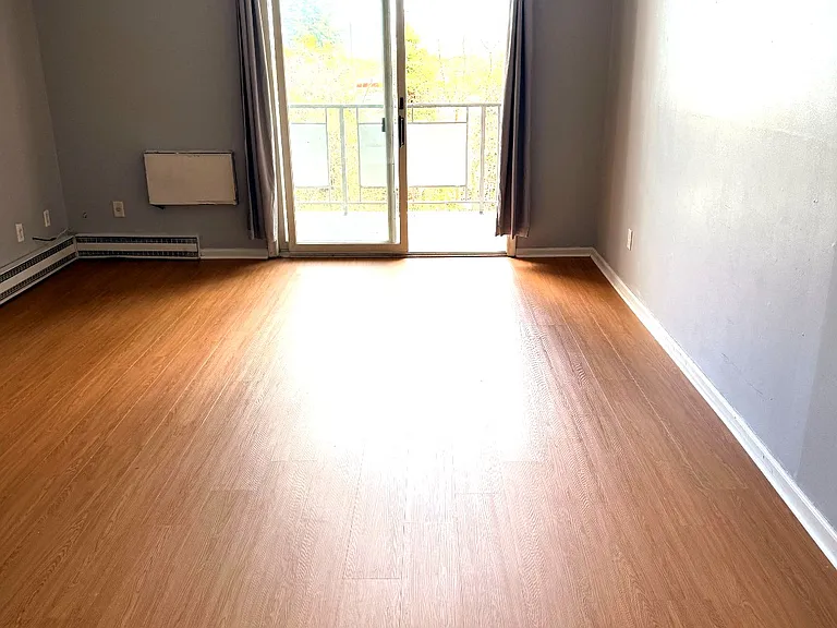 Bright living room with fresh flooring and balcony access