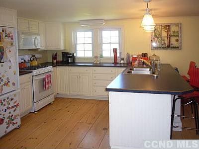 Spacious kitchen with ample workspace and counter with stools.
