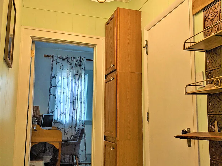 Hallway off kitchen leads to the bathroom and third bedroom