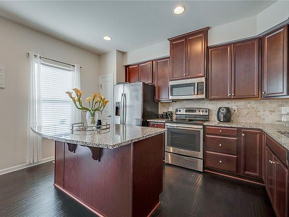 Spacious kitchen w/tile backsplash, s.steel appliances, granite counters,  pantry closet.