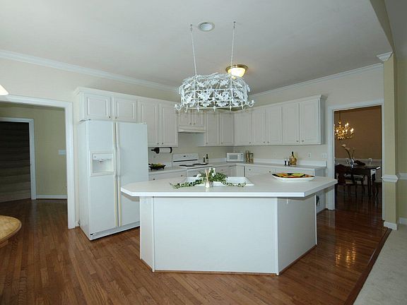 Kitchen features hardwoods, breakfast bar, plenty of cabinets & countertops.