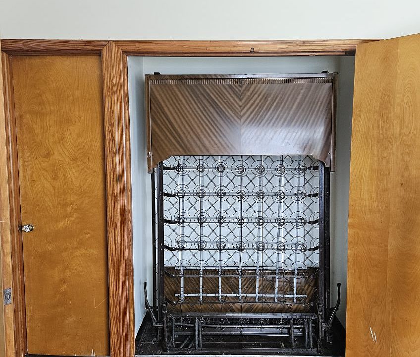 Murphy bed frame propped up inside murphy closet