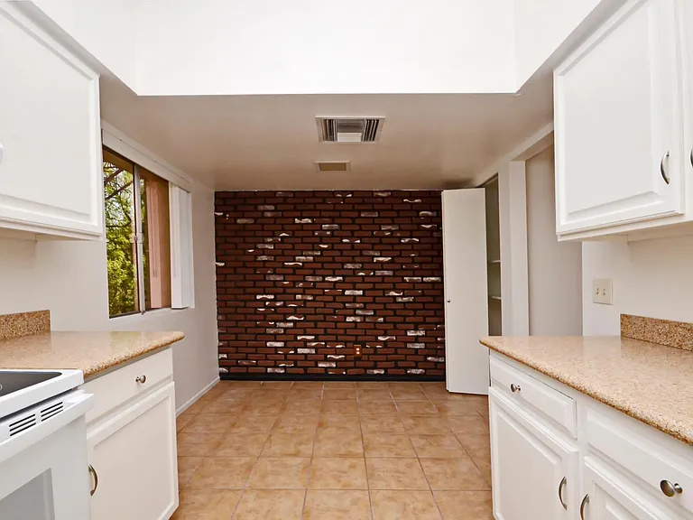 Light and bright galley eat-in kitchen with granite counter tops, new appliances and pantry.