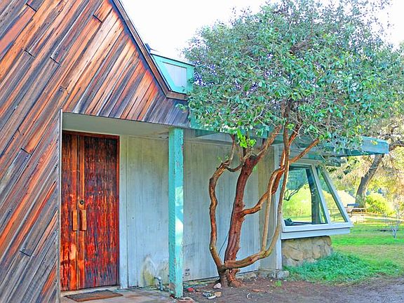 Custom redwood from an old water holding tank with no knots in the wood help frame the unique entryway.