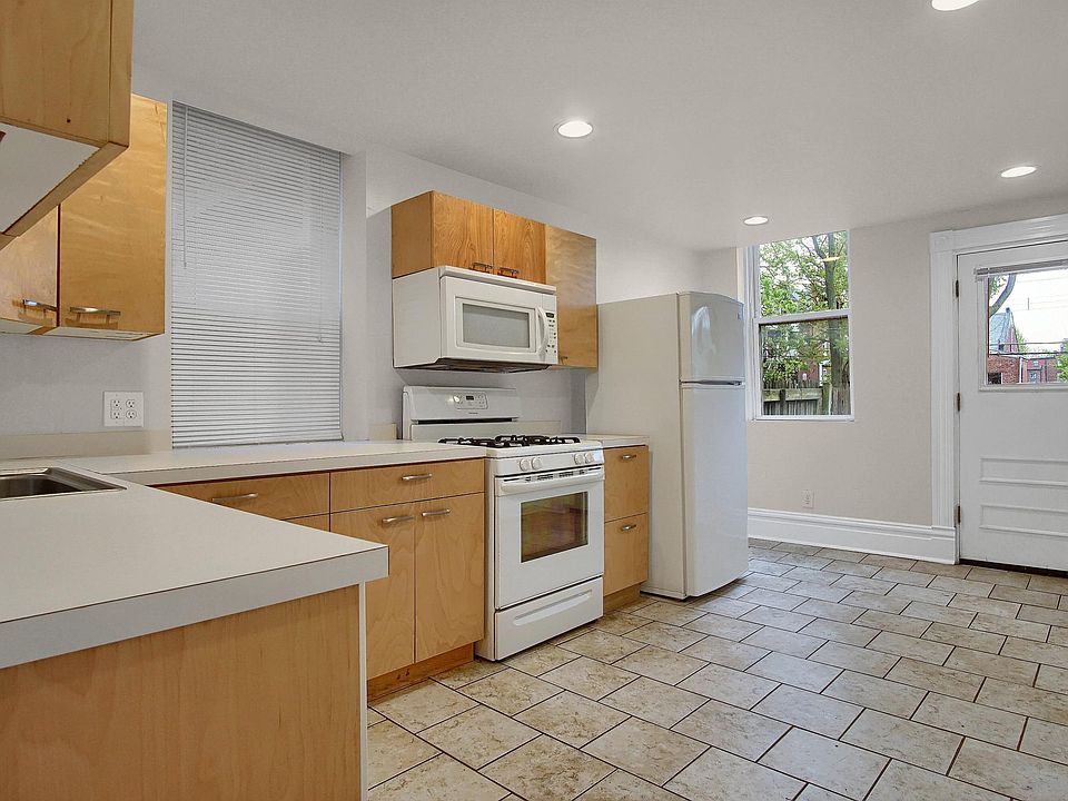 Bright eat-in kitchen with ceramic tile floors, abundant cabinet storage, gas range, and direct access to the backyard and porch_recently updated with a full-size washer/dryer (not pictured) conveniently located beside the refrigerator.