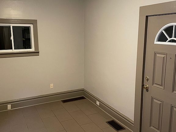 Another picture of the living room and the new exterior door. The living room measures approximately 14 x 10 feet.