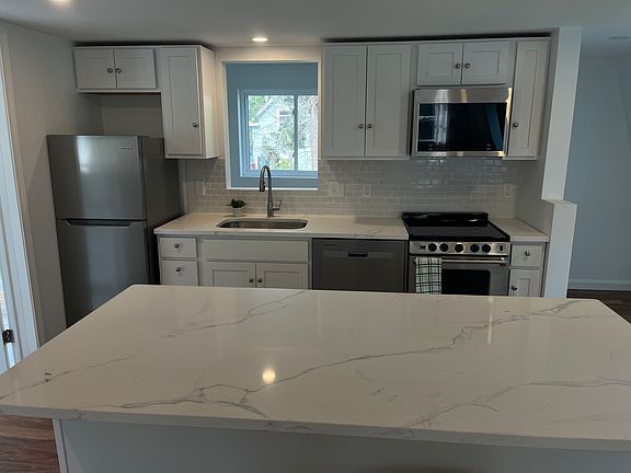 Kitchen with Range, Dishwasher, apartment size fridge and microwave.