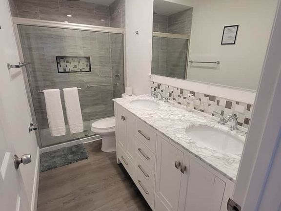 Impeccable modern bathroom with toilet, shower, sink, and essential amenities.