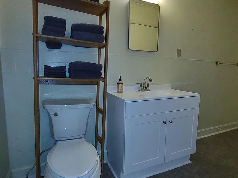 New toilet, vanity, and flooring in bath.